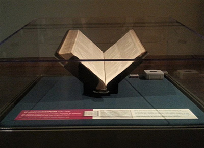 The First Folio sat under a glass case on its altar in the center of a room, displaying Hamlet's famous soliloquy: "To be, or not to be."